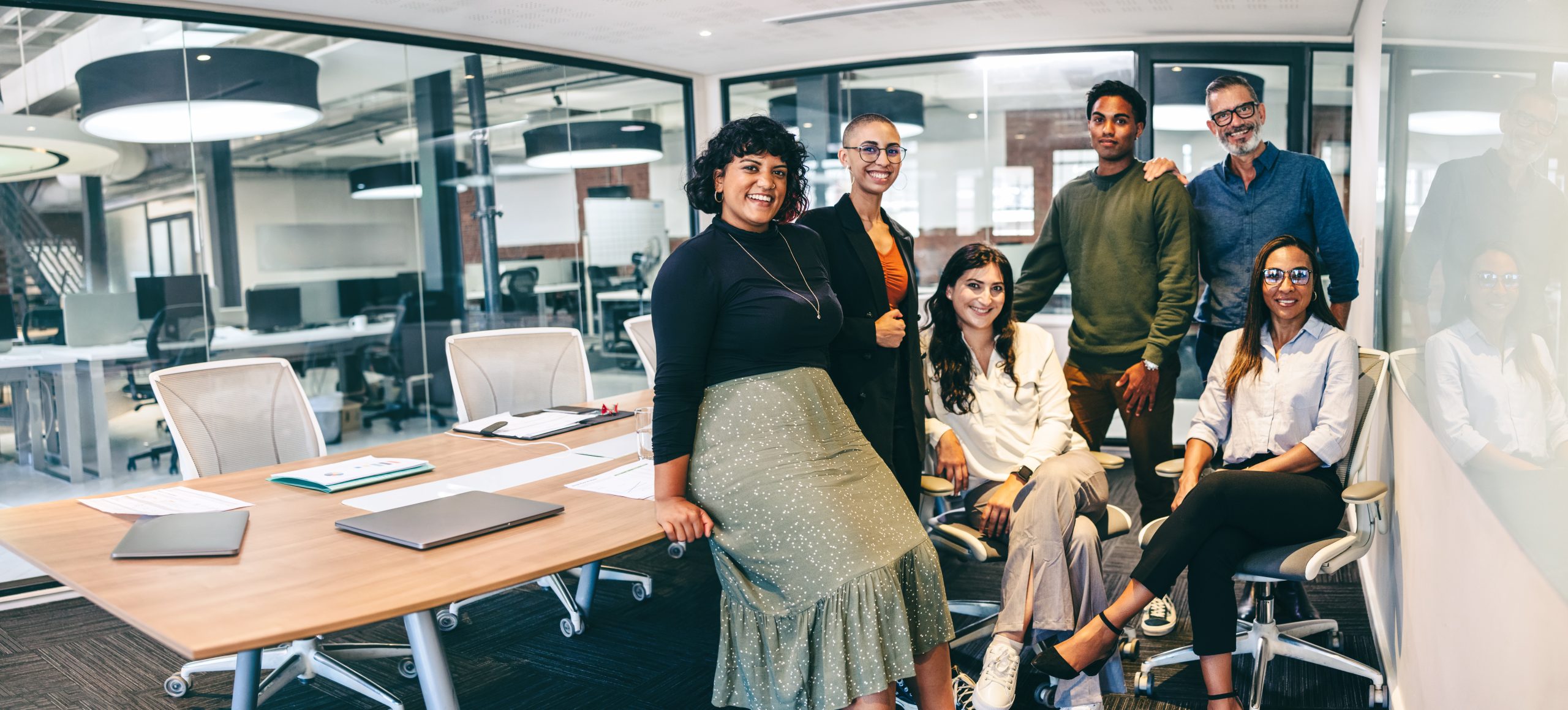 Team,Of,Businesspeople,Smiling,At,The,Camera,In,A,Boardroom.